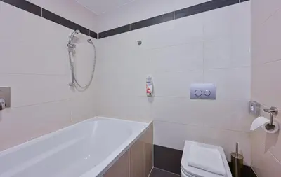 a white bathroom with a tub and a toilet at Hotel Prague Star in Prague