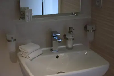 a bathroom with a sink with a mirror and towels at Hotel Prague Star in Prague
