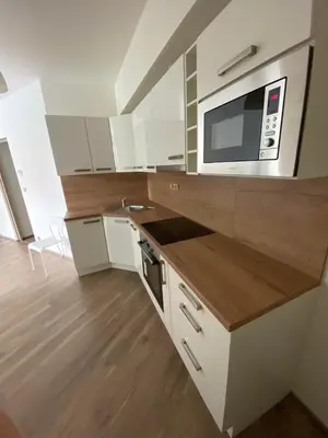 a kitchen with white cabinets and a microwave at Apartment David O2 Arena Prague in Prague