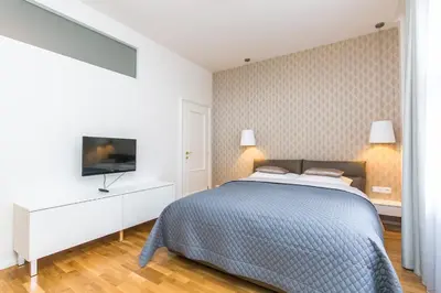 a white bedroom with a bed and a tv at TOP location OLD town brand new 2BD apartment in Prague