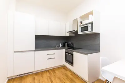 a kitchen with white cabinets and a microwave at TOP location OLD town brand new 2BD apartment in Prague