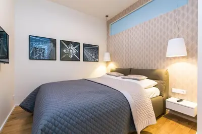 a bedroom with a bed and a wall with pictures at TOP location OLD town brand new 2BD apartment in Prague