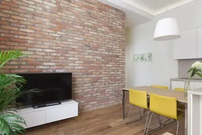 a living room with a brick wall and a table and chairs at UNIQUE Old Town apartments at Palace Dlouha in Prague
