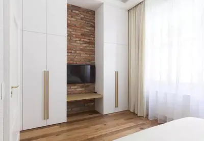 a bedroom with a tv and a brick wall at UNIQUE Old Town apartments at Palace Dlouha in Prague