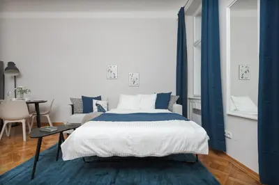 a bedroom with a large bed and a table at AIRSTAY PRAGUE apartment Vinohrady in Prague