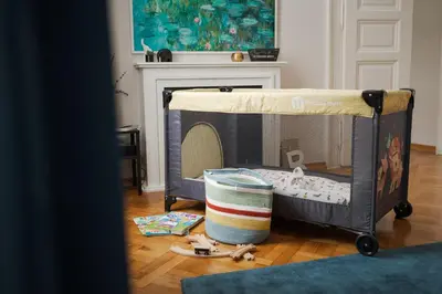 a baby crib with a bed in a living room at AIRSTAY PRAGUE apartment Vinohrady in Prague