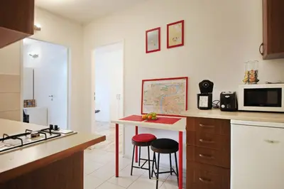 a kitchen with a counter with stools and a microwave at Invalidovna Apartment in Prague