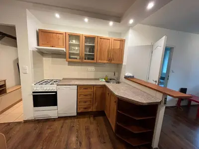 a kitchen with white appliances and wooden cabinets at Invalidovna Apartment in Prague