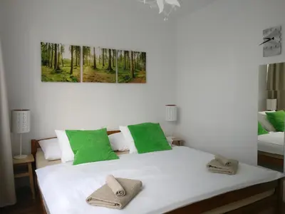 a bedroom with a bed with green and white pillows at Invalidovna Apartment in Prague