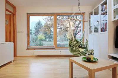 a room with a hammock in a room with a window at Invalidovna Apartment in Prague