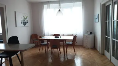 a dining room with a table and chairs at Apartmán Malvazinky in Prague