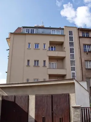 a tall building with a fence in front of it at Apartmán Malvazinky in Prague