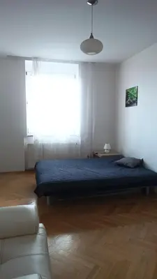 a bedroom with a blue bed and a window at Apartmán Malvazinky in Prague