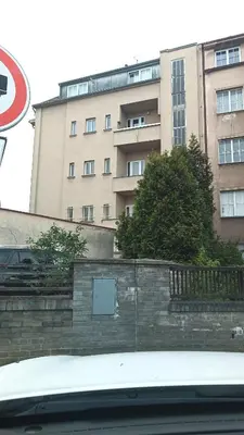 a building in front of a brick wall and a building at Apartmán Malvazinky in Prague