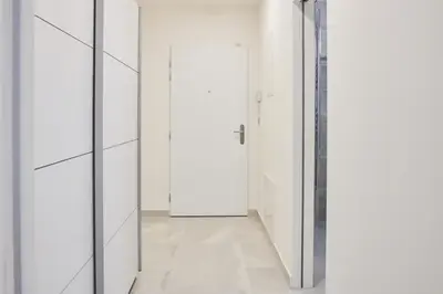 an empty corridor with white walls and a door at Apartments Harfa in Prague