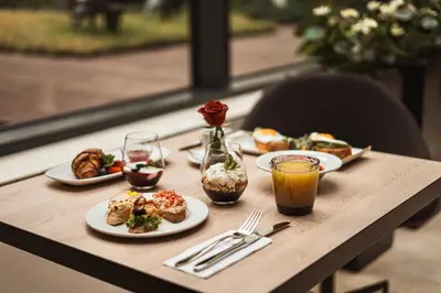 a table with plates of food and drinks on it at Hotel CUBE Prague in Prague