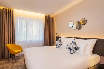 a hotel room with a bed and a yellow chair at Hotel CUBE Prague in Prague