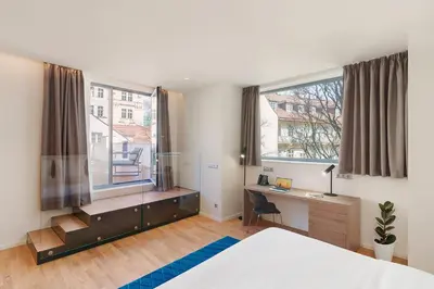 a bedroom with a bed and a desk and a window at Hotel CUBE Prague in Prague