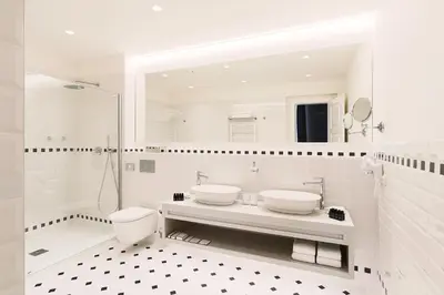 a white bathroom with two sinks and a shower at Hotel CUBE Prague in Prague