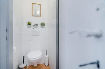 a white bathroom with a toilet and some plants at Charming APT Old Town Prague by Michal&Friends in Prague