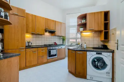 a kitchen with wooden cabinets and a washing machine at APT near OLD TOWN Prague by Michal&Friends in Prague