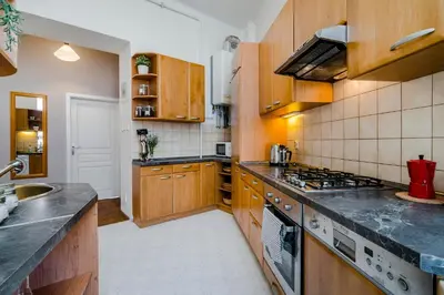 a kitchen with wooden cabinets and a stove top oven at APT near OLD TOWN Prague by Michal&Friends in Prague
