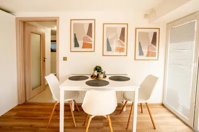 a white dining room with a white table and chairs at Apartmán u Jiříka in Poděbrady