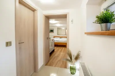 a room with a hallway with a bed and a desk at Apartmán u Jiříka in Poděbrady