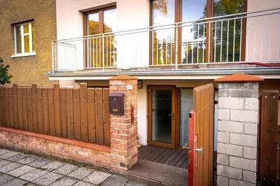 a house with a wooden fence and a balcony at Apartmán u Jiříka in Poděbrady