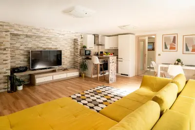 a living room with a yellow couch and a television at Apartmán u Jiříka in Poděbrady