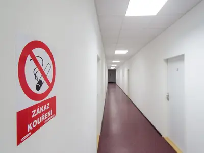 a no smoking sign on a wall in an empty hallway at Hostel BOHEMIA in Prague