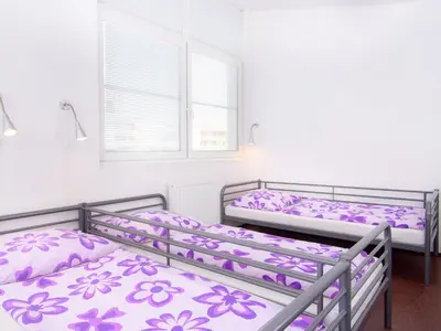 three bunk beds in a room with purple flowers at Hostel BOHEMIA in Prague