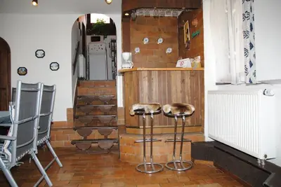 a kitchen with two stools and a brick wall at Chalet Lucie in Mnetěš