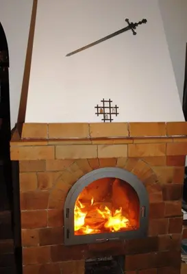 a pizza oven with a cross on top of it at Chalet Lucie in Mnetěš