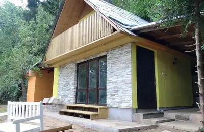 a small house with a bench in front of it at Sazava River Cottage with boating experience in Týnec nad Sázavou