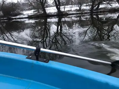 a boat in a body of water with a field at Sazava River Cottage with boating experience in Týnec nad Sázavou