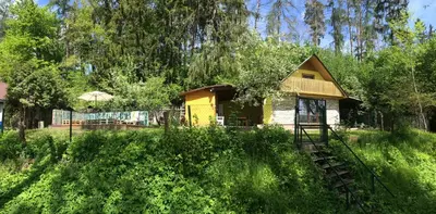 a small yellow house in the middle of a field at Sazava River Cottage with boating experience in Týnec nad Sázavou