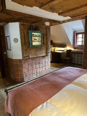 a bedroom with a bed in a room with wooden ceilings at Romantik Hotel U Raka in Prague