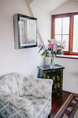 a living room with a couch and a vase of flowers at Penzion Na Staré Poště in Nymburk