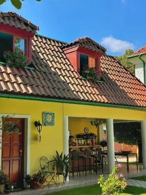 a yellow house with a table and chairs at Penzion Na Staré Poště in Nymburk