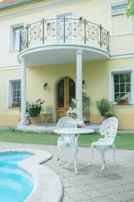 two chairs and a table next to a house at Penzion Na Staré Poště in Nymburk