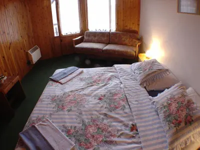 a large bed in a room with a couch at Lovecký hotel Jívák in Loučeň