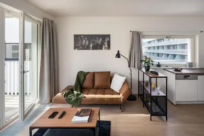 a living room with a couch and a table at Prague Days - Apartment with Balcony and Parking in Trendy New Residential Area in Karlín in Prague