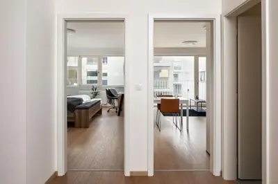 an open hallway with a living room and a dining room at Prague Days - Apartment with Balcony and Parking in Trendy New Residential Area in Karlín in Prague