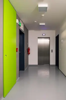 an empty hallway with a green door in a building at Prague Days - Apartment with Balcony and Parking in Trendy New Residential Area in Karlín in Prague
