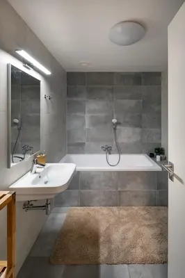 a bathroom with a tub and a sink at Prague Days - Apartment with Balcony and Parking in Trendy New Residential Area in Karlín in Prague