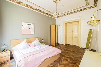 a bedroom with a bed and a chandelier at For celebrations spacious 3BDR apartment with balcony in Prague