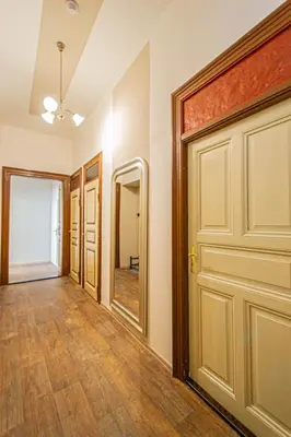 an empty hallway with a door and wooden floors at For celebrations spacious 3BDR apartment with balcony in Prague