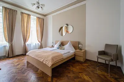 a bedroom with a bed and a chair at For celebrations spacious 3BDR apartment with balcony in Prague