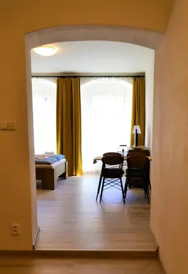 a living room with a table and a dining room at Pension Kotva in Beroun